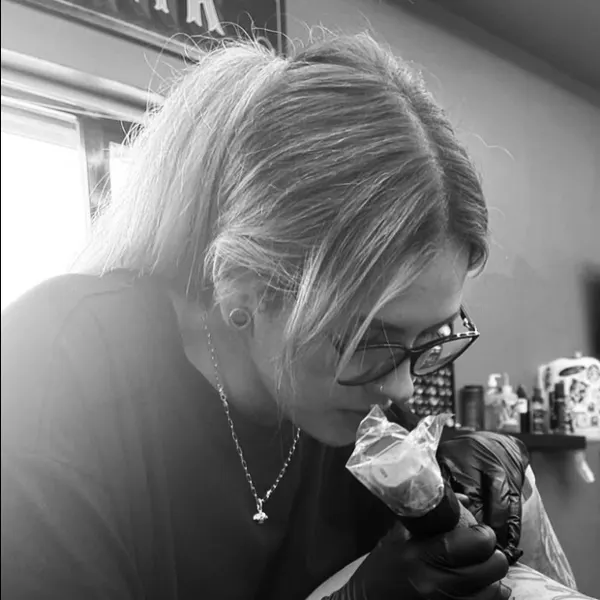 Abbie tattooing a client
