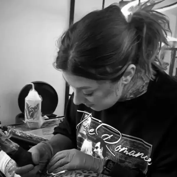 Kayleigh tattooing a client