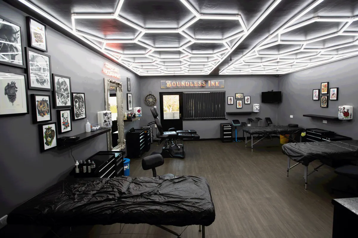 Open-plan tattoo floor with hexagon lighting